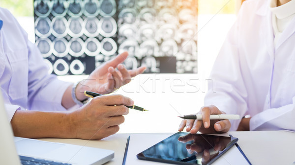 Two doctors analyzing a scan or x-ray film or  explains a CT sca Stock photo © snowing