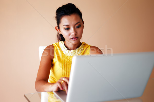 Young woman in a yellow top using a laptop Stock photo © SophieJames