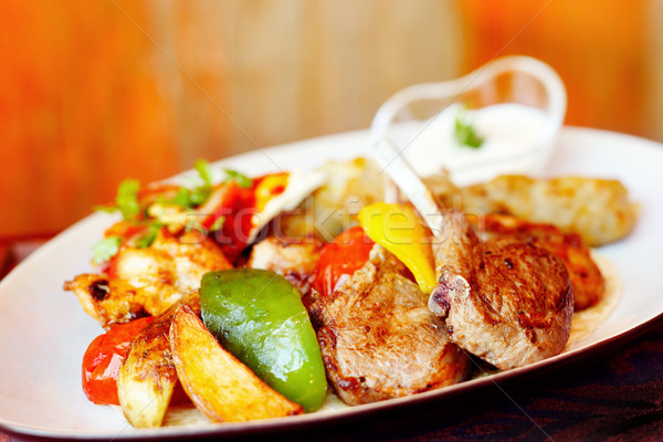 A mixed grill with lamb chops, chicken and capsicum and wedges Stock photo © SophieJames