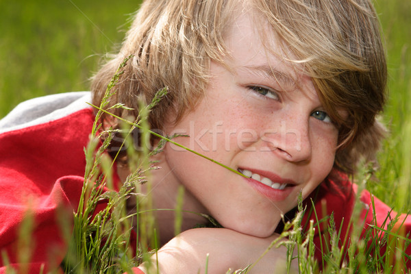 Teenage boy laying in a field of grasses Stock photo © soupstock