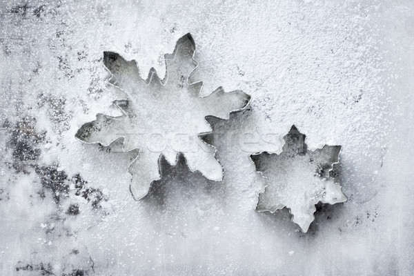Snowflake cookie cutters on a powdered baking sheet Stock photo © soupstock