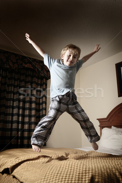 Young boy jumping on the bed Stock photo © soupstock