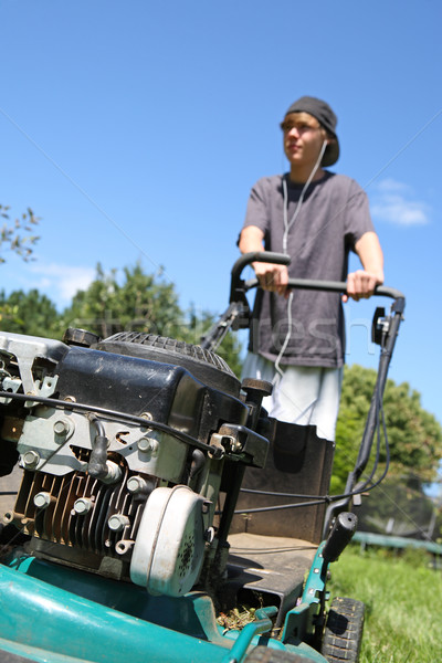 Teenage boy mowing lawn Stock photo © soupstock