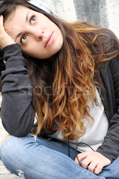 Melancholijny muzyki młoda kobieta słuchania posiedzenia bruk Zdjęcia stock © Spectral