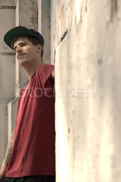 Rapper dől fal fiatal férfi graffiti Stock fotó © Spectral