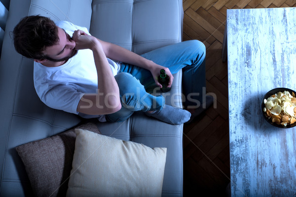 Fiatalember néz tv sültkrumpli sör szenvedély Stock fotó © Spectral