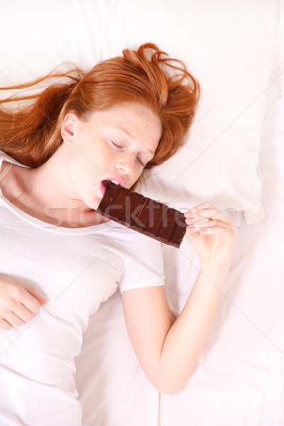 Comer chocolate jóvenes mujer cama Foto stock © Spectral