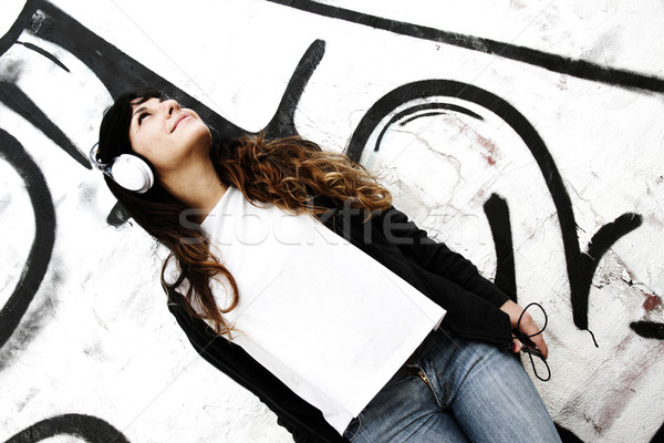 Girl listening to Music while leaning on a Wall Stock photo © Spectral