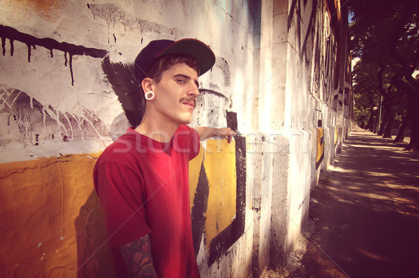 Rapper dől fal fiatal férfi graffiti Stock fotó © Spectral