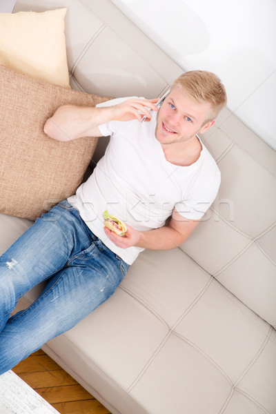 Joven sándwich sofá hablar teléfono agua Foto stock © Spectral