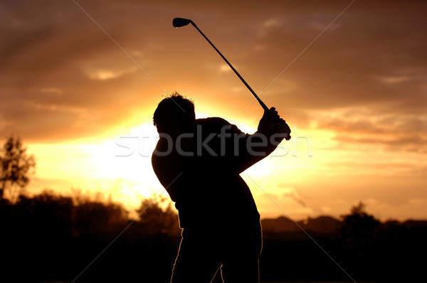 A left handed golfer practices early morning with a beautiful sunrise.  Stock photo © Sportlibrary