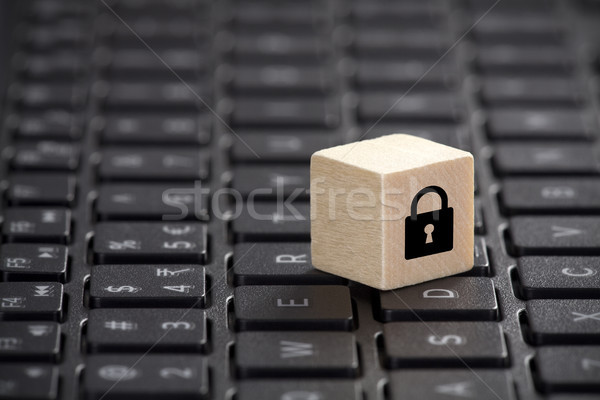 Wooden block with lock graphic on laptop keyboard. Computer security concept.  Stock photo © sqback