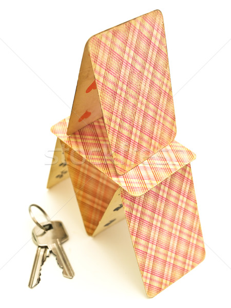 Stock photo: Card house with keys over the white background
