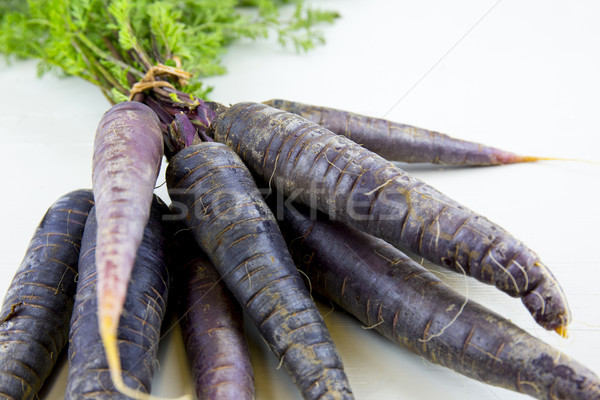 Bunch of heirloom purple carrots, over white and wooden backgrou Stock photo © stefanoventuri
