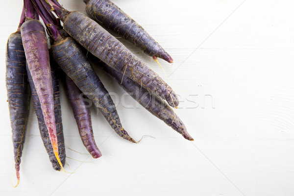 Bunch of heirloom purple carrots, over white and wooden backgrou Stock photo © stefanoventuri