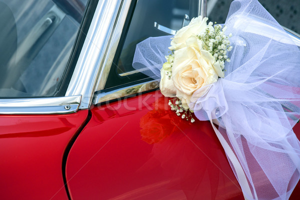 Little flower bouquet with white bow over a red car Stock photo © stefanoventuri