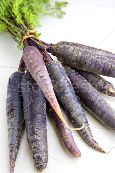 Bunch of heirloom purple carrots, over white and wooden backgrou Stock photo © stefanoventuri