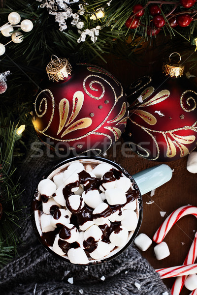 surrounded by warm gray scarf, ornaments, pine bough and candy