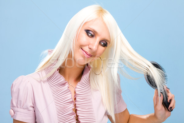 blond woman combing her beautiful long hair Stock photo © stepstock