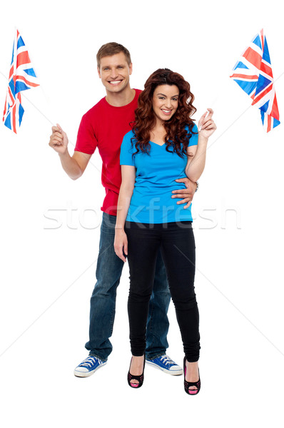 Guy hugging his girlfriend and both holding UK flag Stock photo © stockyimages