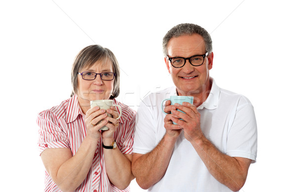 Romantic senior couple holding coffee mugs Stock photo © stockyimages