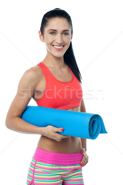 Woman gym instructor holding blue mat Stock photo © stockyimages