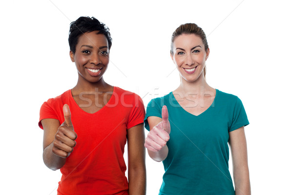 Two happy women with thumbs up Stock photo © stockyimages