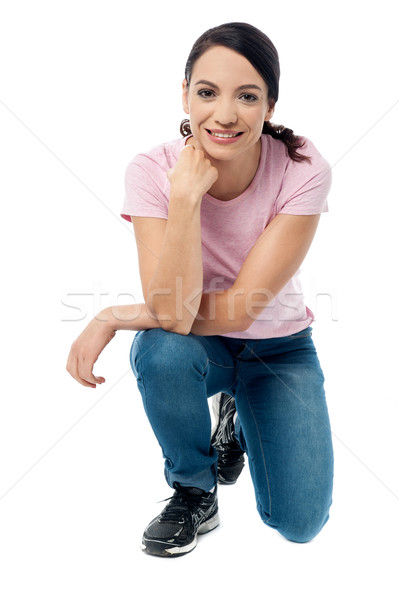 Crouched woman posing casually Stock photo © stockyimages