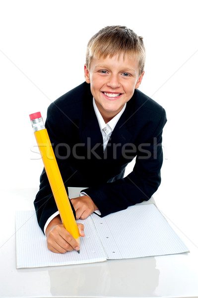 Bájos iskolás fiú ír megbízás mosolyog kamera Stock fotó © stockyimages