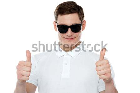 Handsome guy gesturing double thumbs up Stock photo © stockyimages
