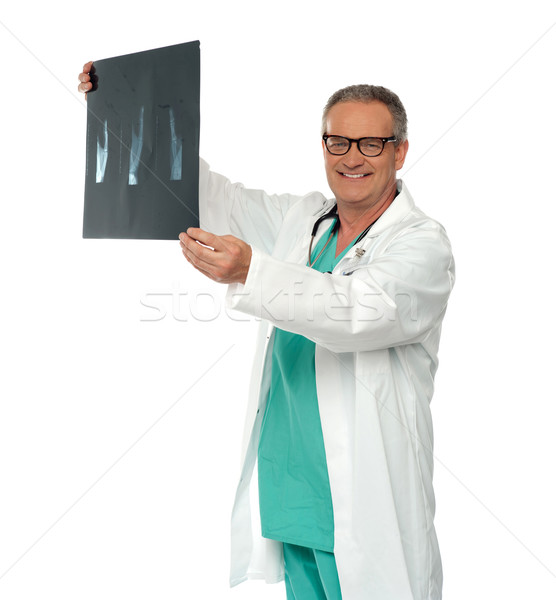 Smiling doctor in glasses reviewing x-ray report Stock photo © stockyimages