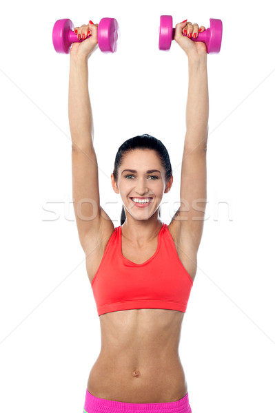 Happy fitness woman lifting dumbbells Stock photo © stockyimages