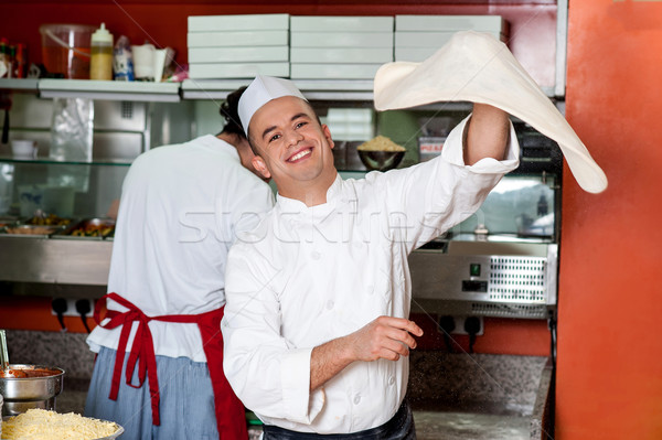 Chef throwing the pizza base dough Stock photo © stockyimages