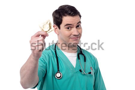 Doctor holding condom over white Stock photo © stockyimages