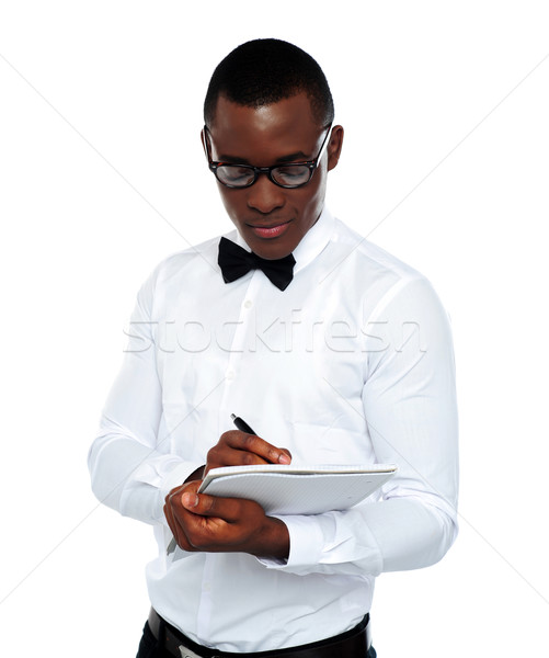 Confident young man writing on notepad Stock photo © stockyimages