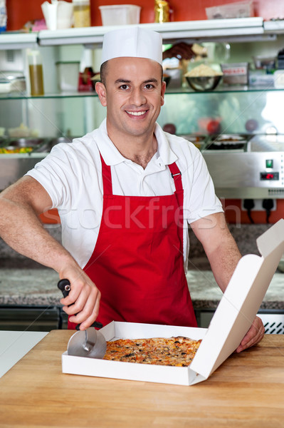 Male chef using pizza cutter Stock photo © stockyimages