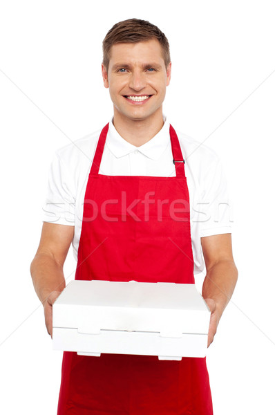 Chef rojo uniforme ofrecimiento caja de pizza sonriendo Foto stock © stockyimages