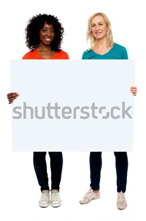 Big billboard presented by casual girls. Full length Stock photo © stockyimages