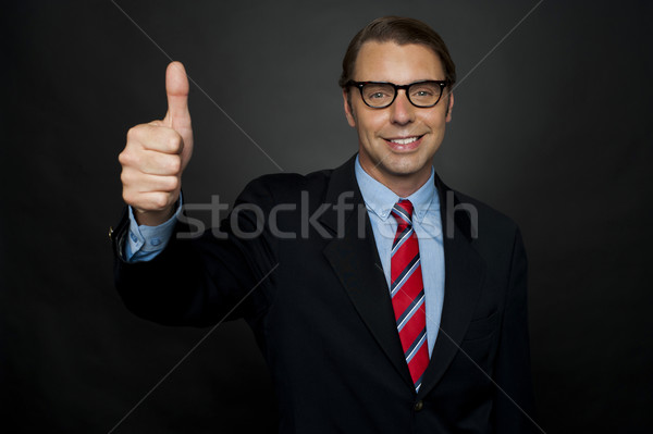 Businessman showing thumbs up sign to his team Stock photo © stockyimages