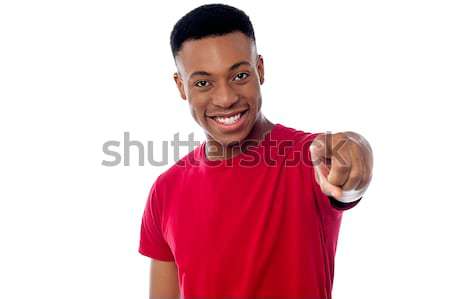 Stock photo: Cheerful guy pointing towards camera