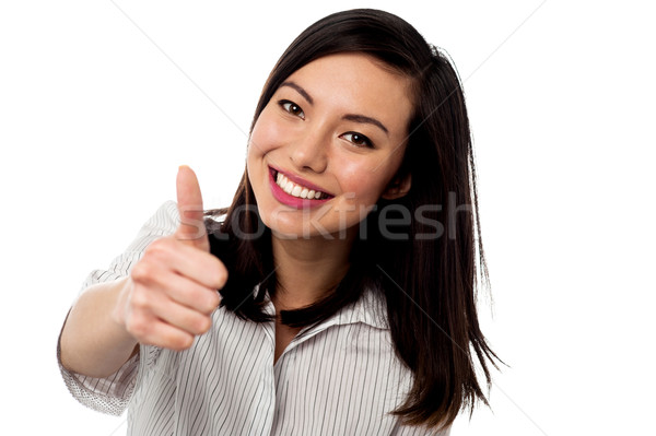 Smiling young woman showing thumbs up Stock photo © stockyimages