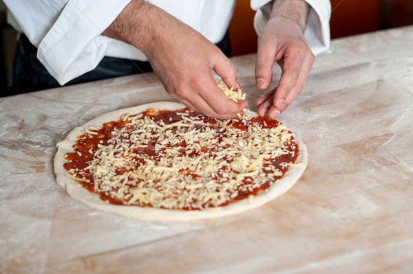 Stock photo: Male chef preparing pizza, closeup shot