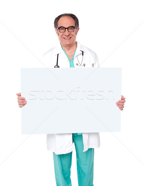 Male doctor posing with white blank billboard Stock photo © stockyimages