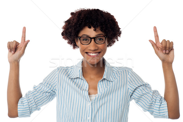 Excited woman pointing upwards Stock photo © stockyimages