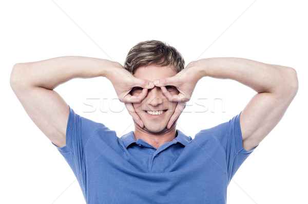 Handsome young man gesturing and smiling Stock photo © stockyimages