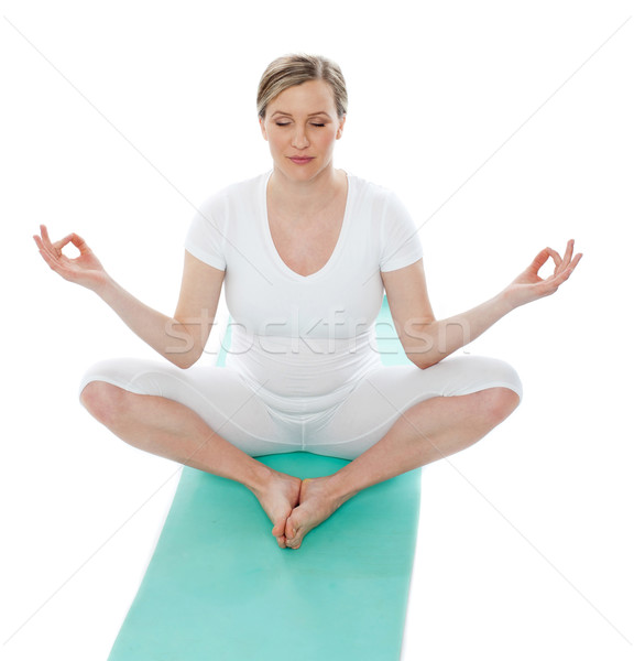 Young woman meditating in lotus pose Stock photo © stockyimages