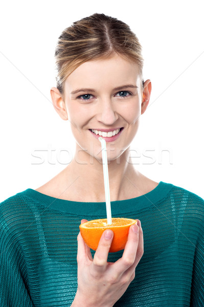 Girl sipping orange juice through straw Stock photo © stockyimages
