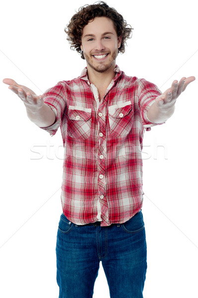 Young casual man welcoming you Stock photo © stockyimages