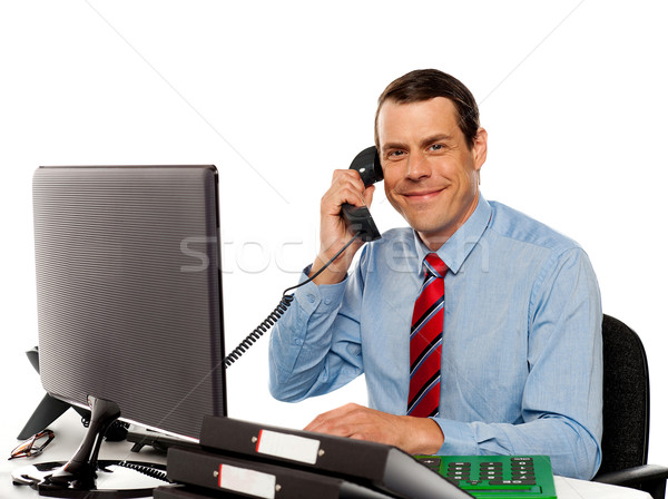 Businessman talking on phone, handling clients Stock photo © stockyimages