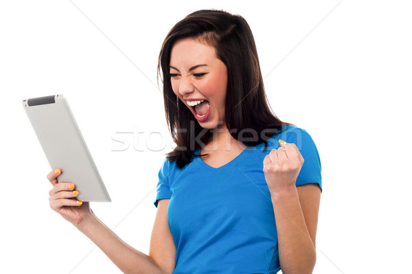 Joyous girl clenching her fist in excitement Stock photo © stockyimages